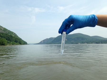 A sample that will be analyzed for optical brighteners pauses for a portrait with the Hudson Highlands as backdrop. (Photo by Dan Shapley/Riverkeeper)