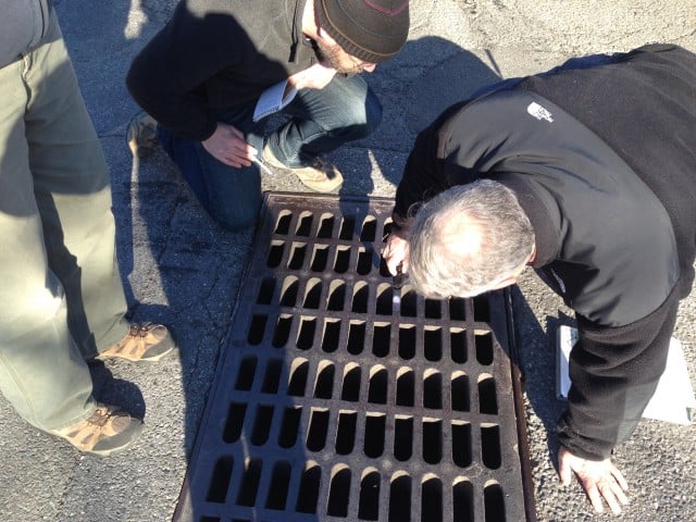 Riverkeeper and EPA staff inspect a stormwater drain. Even those storm drains that weren’t the cause of the illicit dumping were foul: gasoline and automotive oils produced rainbow sheens on the stagnant water within them, and many were filled with garbage and cigarette butts destined for discharge into the Sparta Brook. (Photo by Jen Epstein)